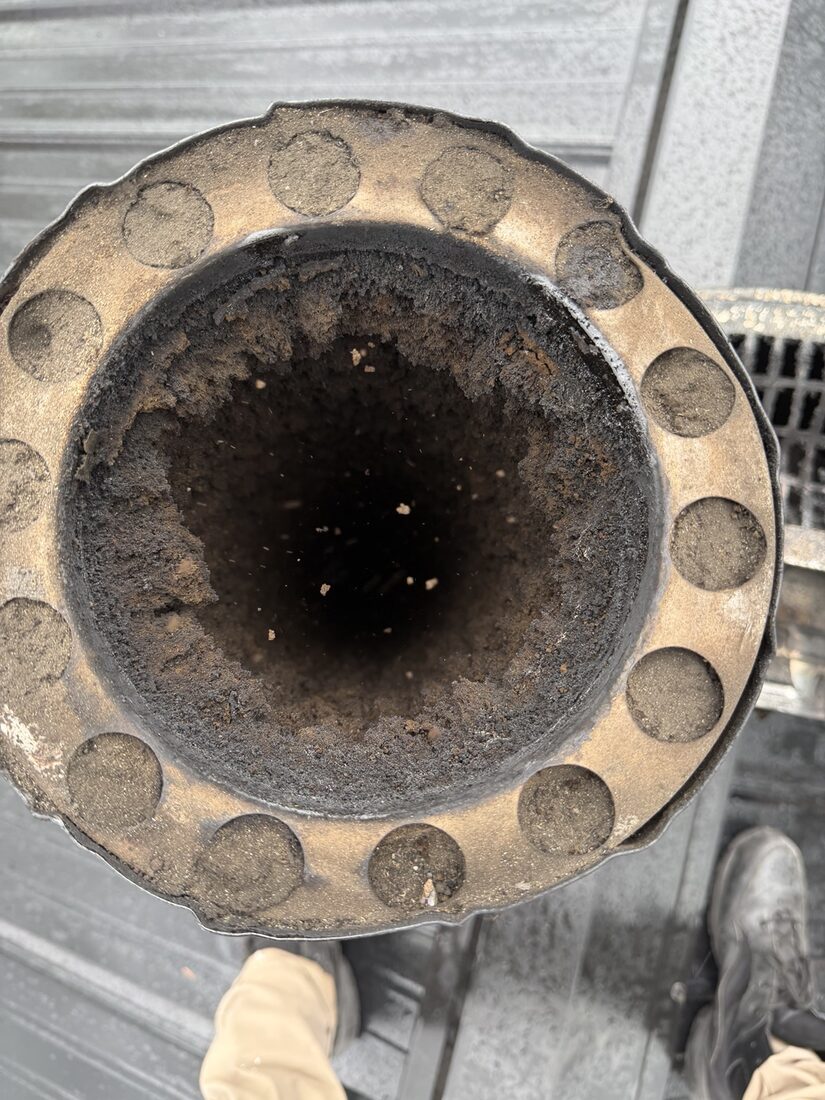 Chimney flue caked with black creosote before cleaning
